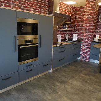 Cuisine grise mate et tons bois à la décoration industrielle réalisée par Espace Falaise